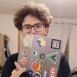 Jack Rendor hiding his smile behind a laptop that is converted in stickers